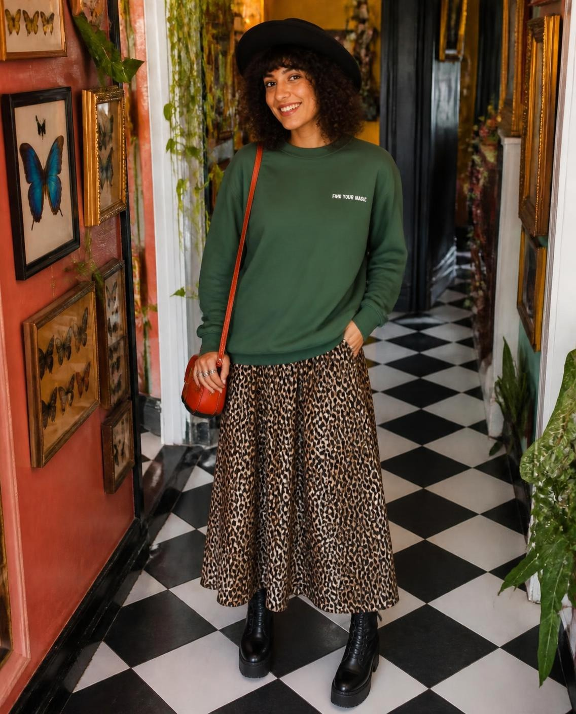 Compass Crewneck Sweatshirt. A green crewneck sweatshirt with a The infinity style Studio compass logo.  Keep you looking stylish, warm and comfy on your confidence recovery journey. Green crewneck front view Model