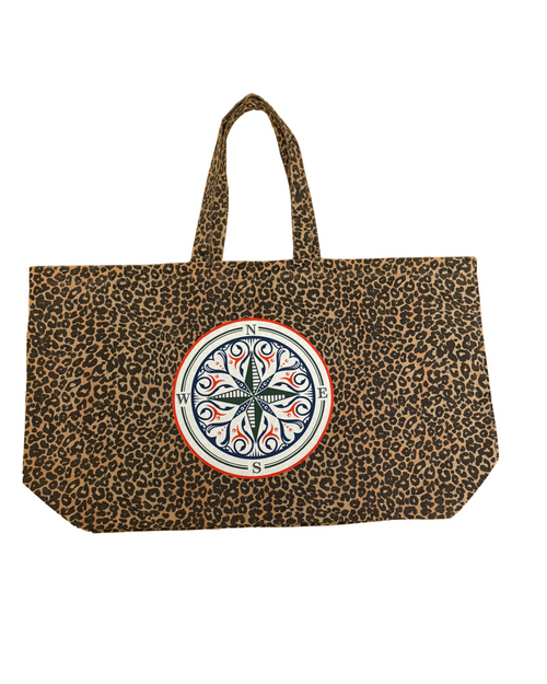 A leopard print tote bag with two top handles and a large circular compass design on the front, set against a plain white background. You can put everything you'll need in out on your confidence recovery journey. Front side